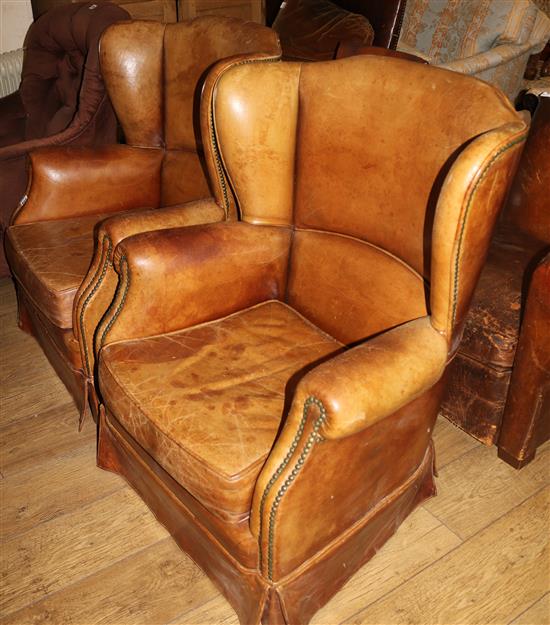 A pair of French 1940s brown leather armchairs